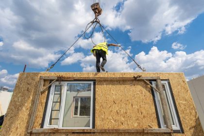 Bâtiment préfabriqué moderne installé sur un chantier avec panneaux de construction autour